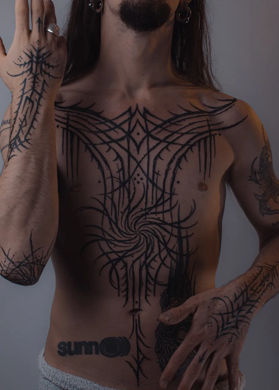 Thorny blackwork across the chest, forearms and hands