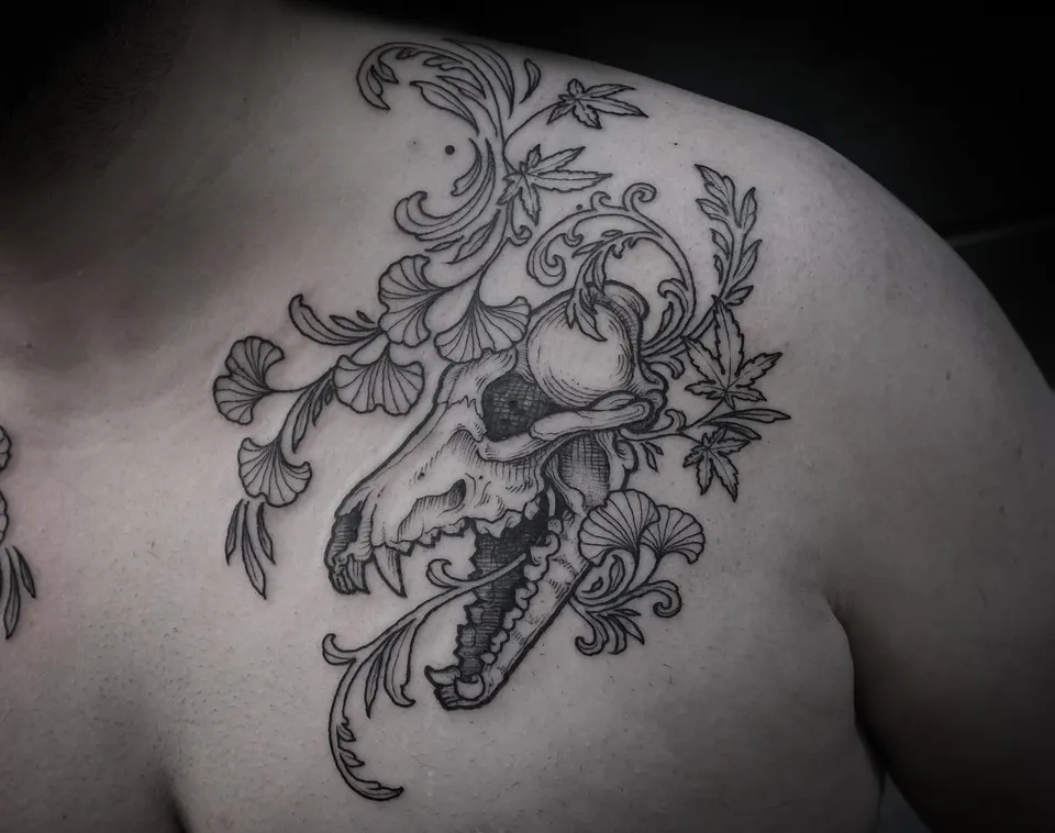 Wolf skull with ginkgo and maple leaves tattooed on the shoulder