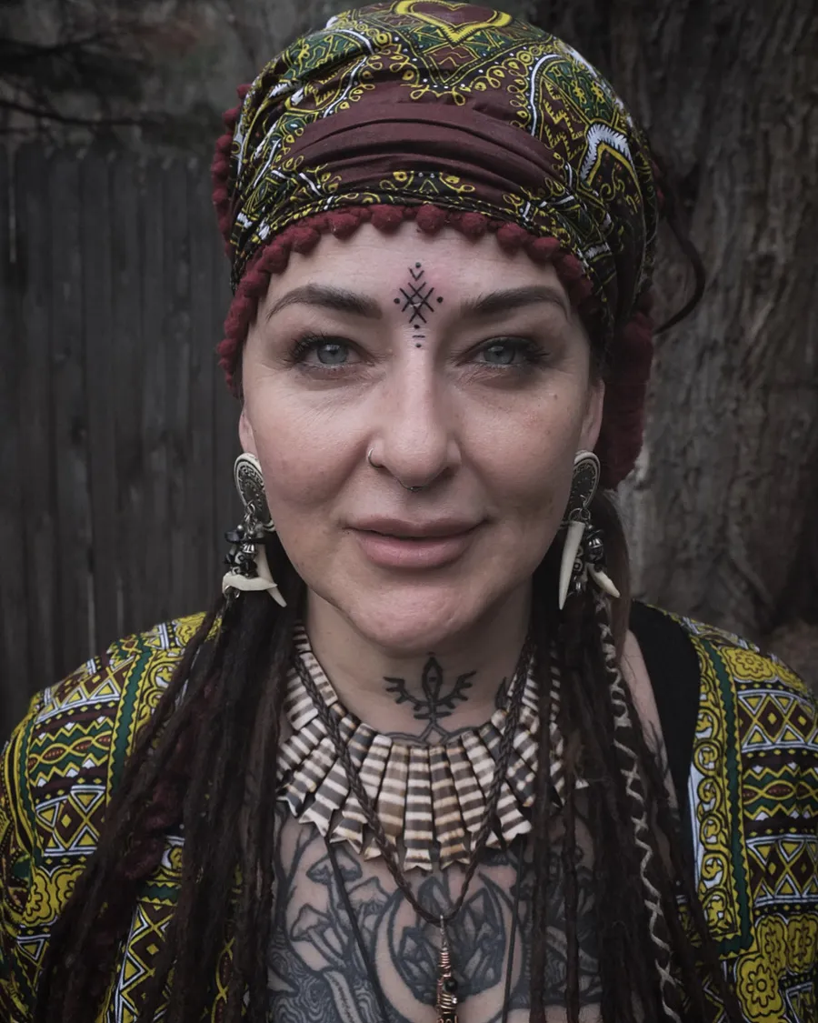 Small ornamental tattoos on the forehead and throat